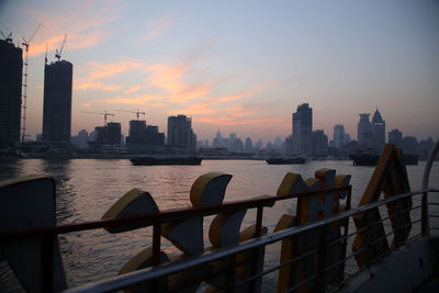 Huangpu river and buildings in city against sky seen from ferry boat