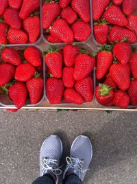 Low section of person standing by strawberries for sale in market