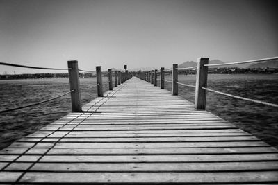 Pier on lake against clear sky