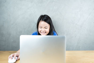 Woman using phone while sitting on table