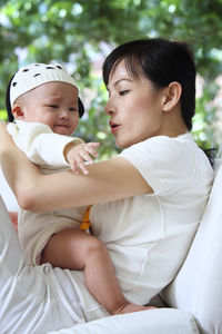 Close-up of mother with crying daughter sitting at home