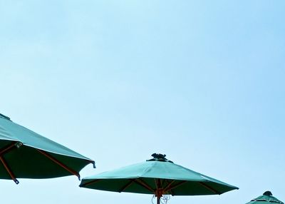 Low angle view of parasols against clear sky