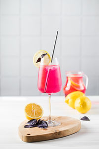 Refreshing lemonade made of red basil and lemon in bakala on a wooden board. a summer drink.