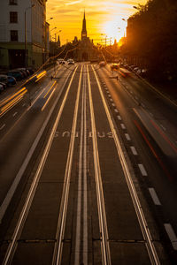 Light trails on road in city against sky at sunset