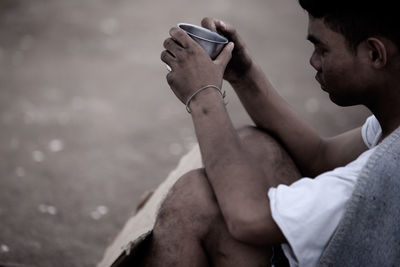 Side view of young man using mobile phone