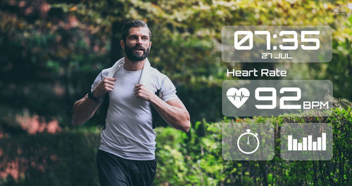 Man running in the park. runner check heartbeat, steps and distance. technology, health concept.