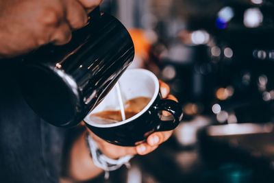 Midsection of man pouring coffee