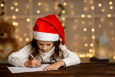 Portrait of young woman writing on book