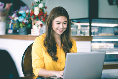 Portrait of smiling young woman using mobile phone