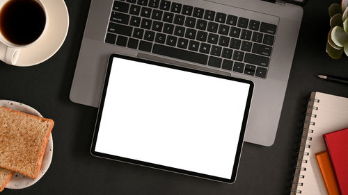 High angle view of coffee and laptop on table