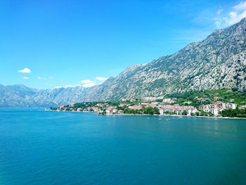 Scenic view of sea and mountains against clear blue sky