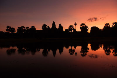 Reflection of trees in lake during sunset