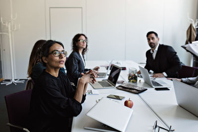 Business people sitting at conference table concentrating during meeting in board room