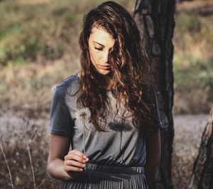 Mid adult woman standing on tree trunk