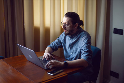 Young woman using laptop at home
