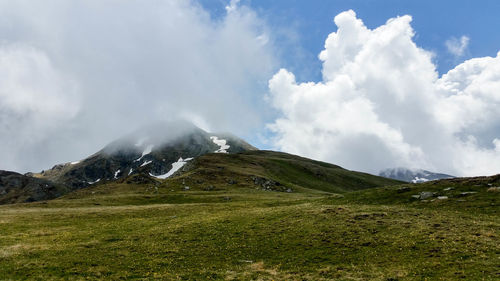 Scenic view of mountains against cloudy sky