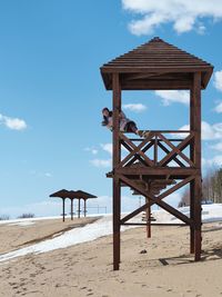 Lifeguard hut on beach against sky