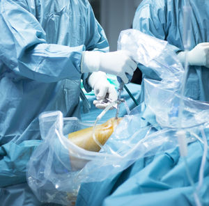 Midsection of surgeons performing surgery on patient