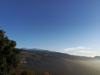 Scenic view of mountains against clear blue sky