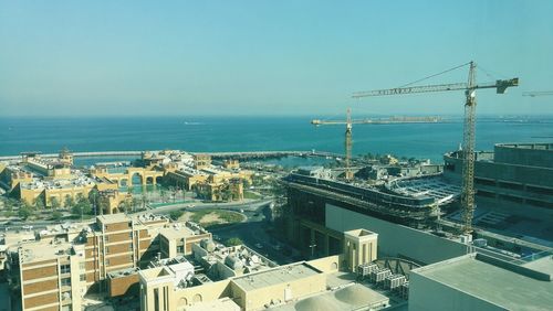 High angle view of cityscape by sea against clear sky