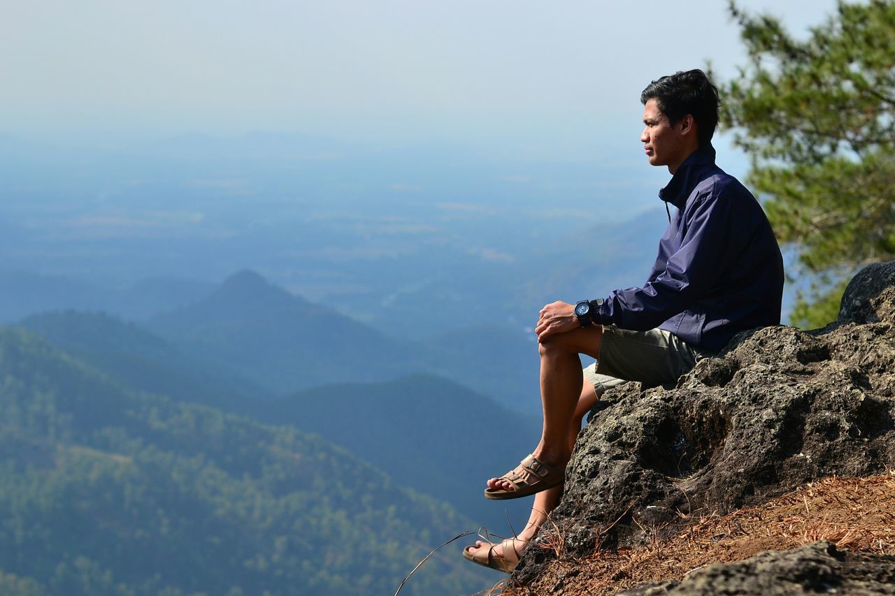 young adult, lifestyles, mountain, leisure activity, casual clothing, full length, person, young men, standing, mountain range, landscape, sky, nature, tranquility, scenics, looking at camera, tranquil scene