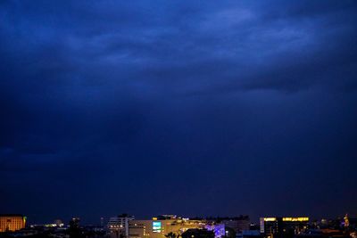 Illuminated buildings in city against sky at night