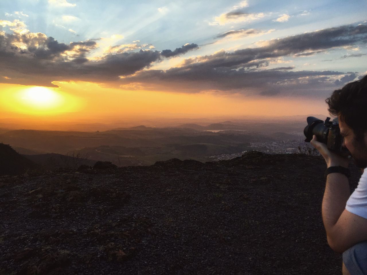 MAN PHOTOGRAPHING AT SUNSET