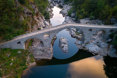 Arch bridge over river against sky