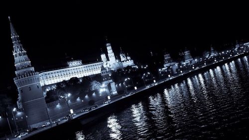 Illuminated bridge over river at night