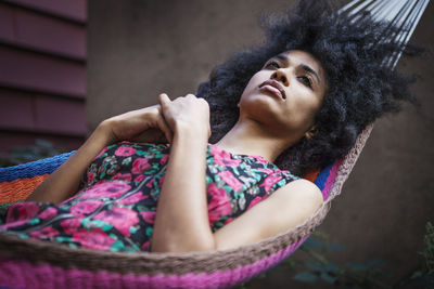 Woman looking away while resting on hammock