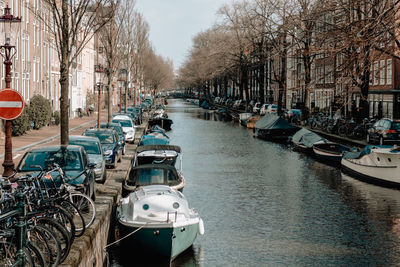 Boats moored in canal along city