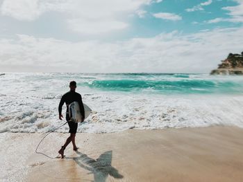 Full length of man at beach against sky