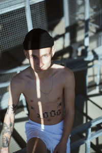 Portrait of young man sitting on railing