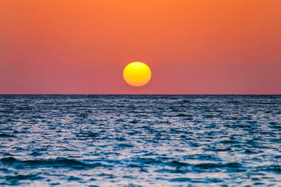 Scenic view of sea against orange sky