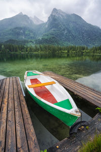 Boats moored on lake against mountains