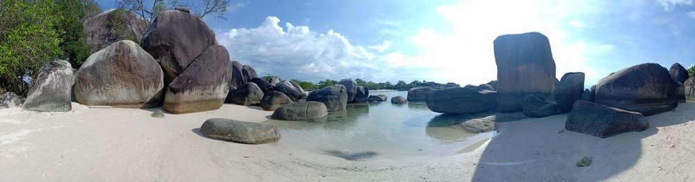 Panoramic shot of rocks on beach against sky