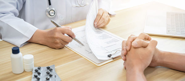 Midsection of doctor examining patient in clinic