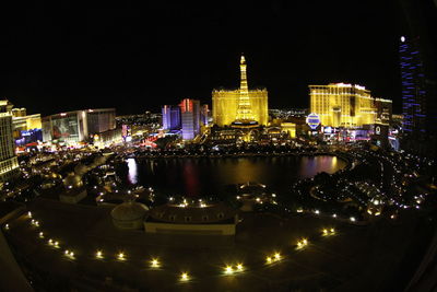 Illuminated cityscape against sky at night