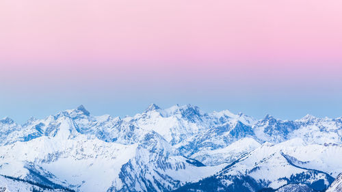 Scenic view of snowcapped mountains against sky during sunset