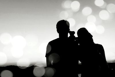 Silhouette couple standing against sky