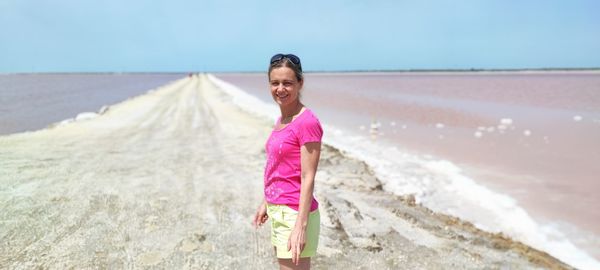 Portrait of young woman standing at beach