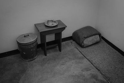 High angle view of empty bench on table against wall