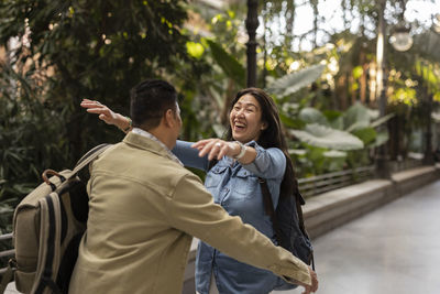 Happy mature woman embracing man on footpath