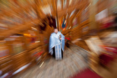 Blurred motion of priest in church