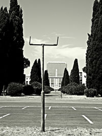 Empty road by buildings against sky