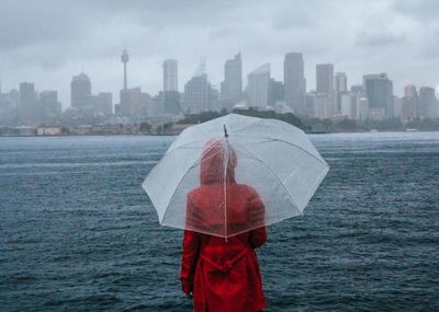 Person with umbrella standing in rain during rainy season