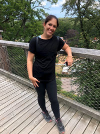 Portrait of a smiling woman standing on footbridge