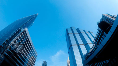 Low angle view of modern buildings against clear blue sky