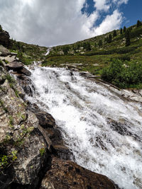 Scenic view of waterfall against sky