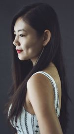 Portrait of a young woman against black background